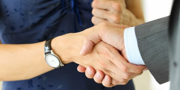 Businessman and woman shake hands as hello in office closeup. Friend welcome, introduction, greet or thanks gesture, product advertisement, partnership approval, arm, strike a bargain on deal concept